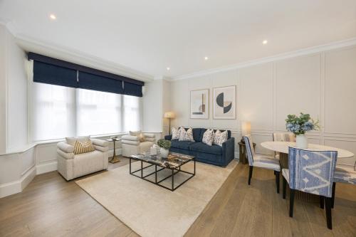 a living room with a couch and a table at Buckingham & Lloyds Knightsbridge in London