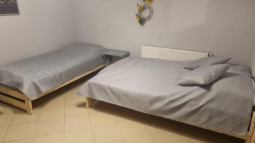 a bedroom with two beds and a clock on the wall at Przystań nad Dłubnią in Wysocice