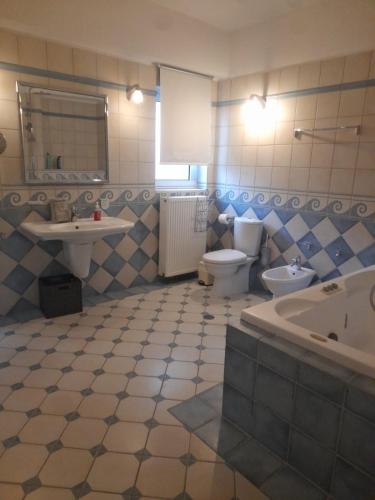 a bathroom with a toilet and a sink and a tub at Kings and Queens 1 in Larisa