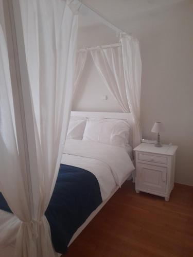 a bedroom with a white bed with a canopy at Kings and Queens 1 in Larisa