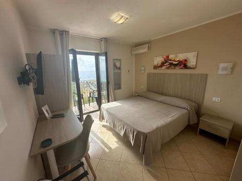 a small bedroom with a bed and a window at Hotel Normanni in Praia a Mare