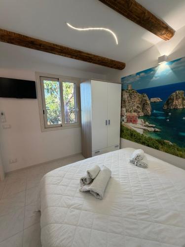 a bedroom with a large white bed with towels on it at Scopello Guidaloca Villas in Scopello
