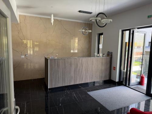 a large bathroom with a shower with a tile wall at Pensiunea LOFT Căciulata in Caciulata