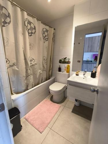 a bathroom with a toilet and a sink and a shower curtain at Centro Vista Al Mar san Martin Coliving in Antofagasta