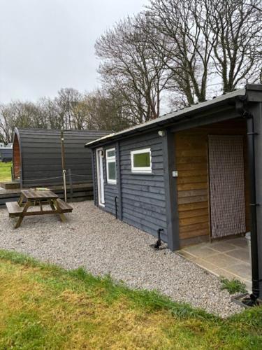 a small shed with a picnic table and a picnic table at Trevessa camping pod in Saint Erth