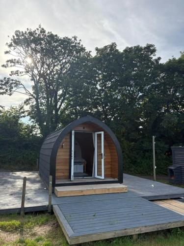a small cabin with a window on a deck at Trevessa camping pod in Saint Erth