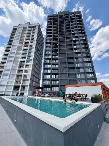two tall buildings with a swimming pool in front of two buildings at Loft de Lujo en Torre Punta Mayor frente a Plaza Mayor en León Gto in Miravalle