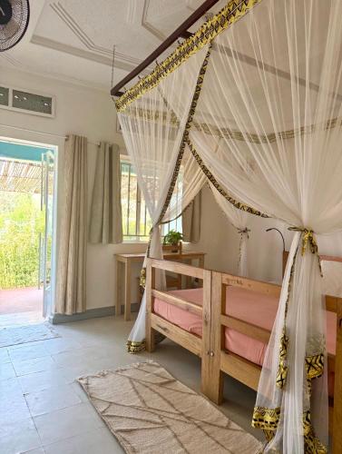 a bedroom with a bed with a canopy at Villa Katwe in Masaka