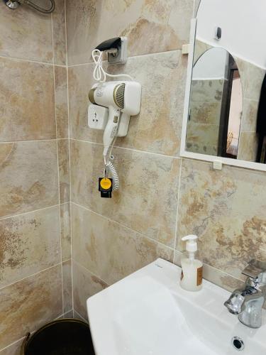 a bathroom with a hair dryer on the wall next to a sink at Hotel la renaissance tata in Tatta