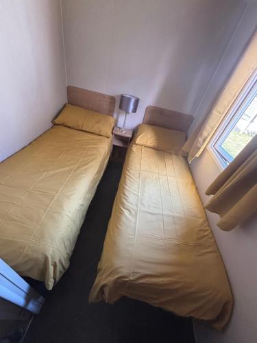 two beds in a small room with a window at Ocean View At Glade in Bucks Mills