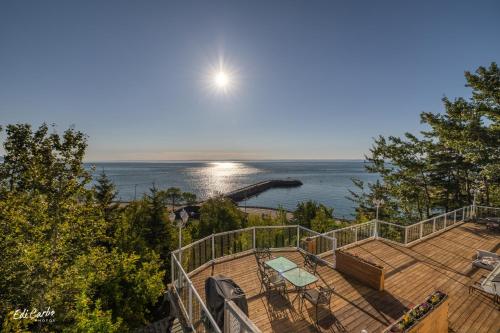 a deck with a view of the ocean and the moon at La Maison Jaune in La Malbaie