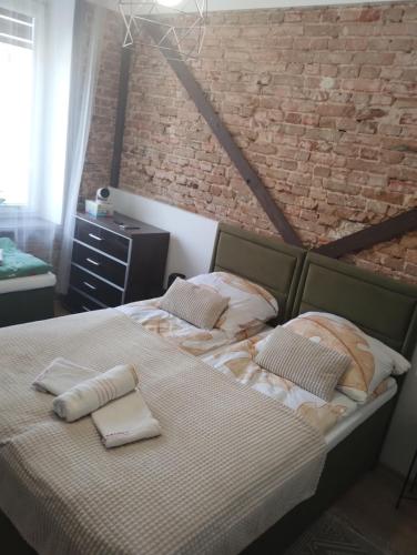 a bedroom with a large bed with a brick wall at Apartament rodzinny SAKURA in Jędrzejów