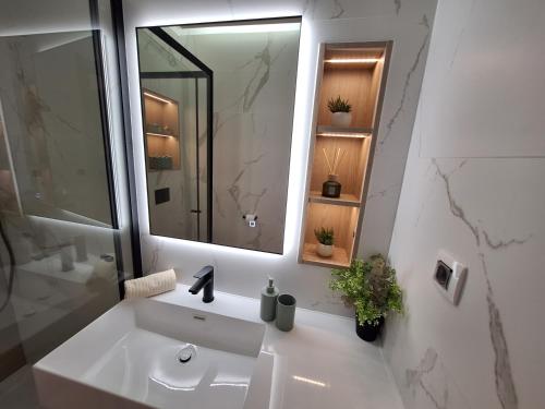 a white bathroom with a sink and a mirror at The Golden Island apartments in Krk