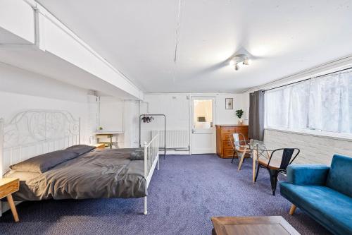 a bedroom with a bed and a table and a couch at Lee Valley Lodge Ground Floor in Cheshunt