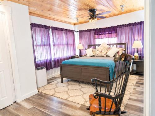 a bedroom with a bed with purple curtains at 3BR St Pete Home Sleeps 6 Private Backyard 15 Min to Beach in St. Petersburg