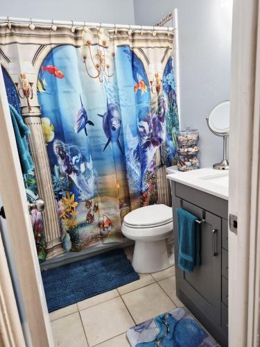 a bathroom with a mermaid shower curtain at 3BR St Pete Home Sleeps 6 Private Backyard 15 Min to Beach in St. Petersburg