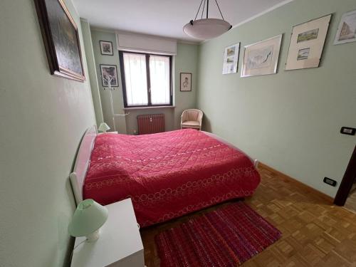a bedroom with a bed with a red blanket at La Chimera in Robilante