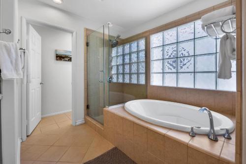 a bathroom with a tub and a shower and a window at Near Oceanside Pier! Pirate in Oceanside