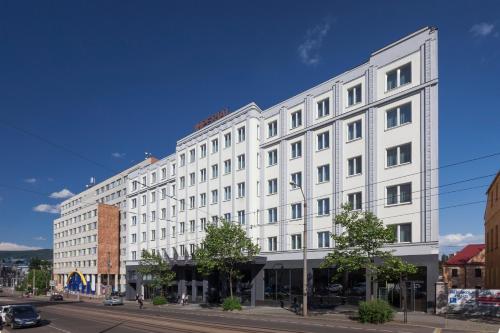 un gran edificio blanco en una calle de la ciudad en Pytloun Imperial Design Suites en Liberec