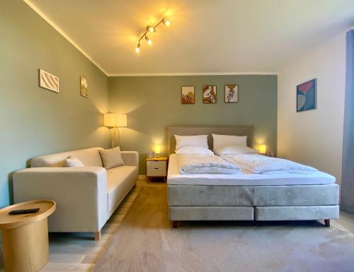 a bedroom with a bed and a couch at Weiher Apartment mit Terrasse & Parkplatz in Kulmbach