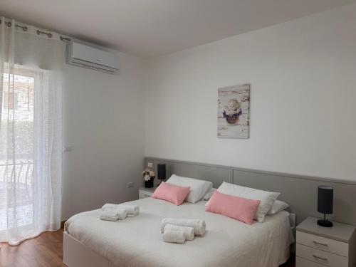a bedroom with a large bed with pink and white pillows at BnB Nuova Vita in Paola