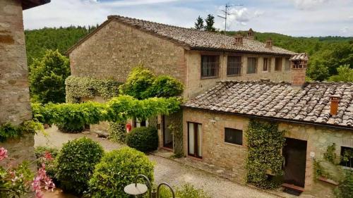 an old stone house with ivy on the roof at Holistic Hotel MadreSelva in Casole dʼElsa