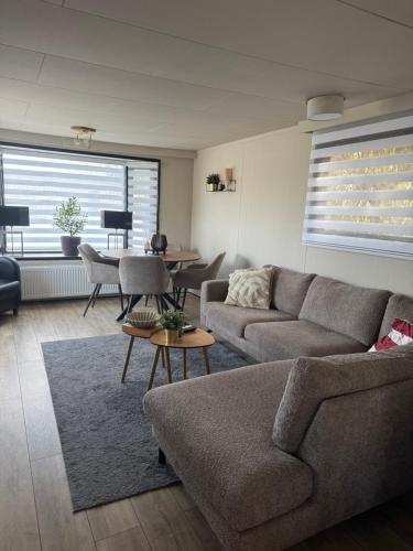 a living room with a couch and a table at Chalet Linée in bosrijke omgeving Anloo in Anloo