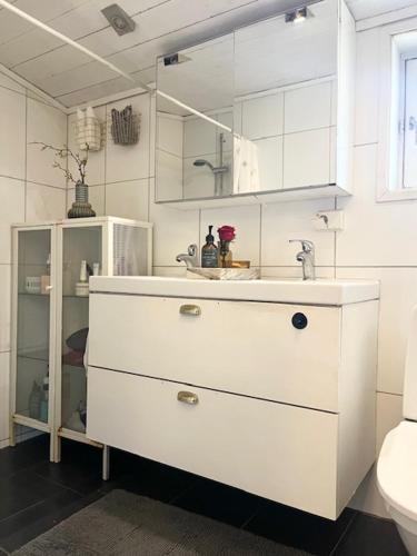 a white bathroom with a sink and a mirror at Brightside House in Kristiansand