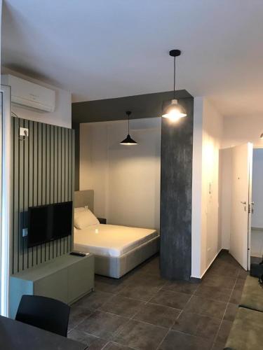 a bedroom with a bed and a flat screen tv at Beach Studio Apartment in Dhërmi