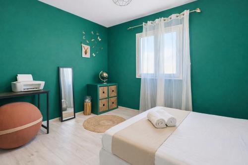 a bedroom with green walls and a bed with two towels at Maison de charme, Gorges Ardèche et Nature in Vagnas