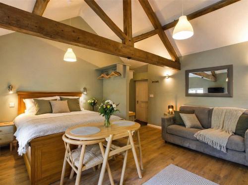 a bedroom with a bed and a table and a couch at Wagtail Lodge in Foy