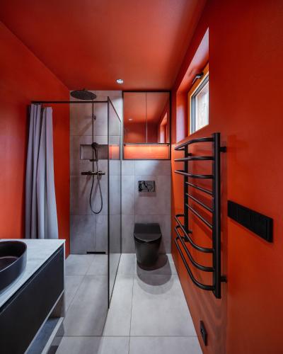 an orange bathroom with a shower and a toilet at Kabiny Kravák in Znojmo