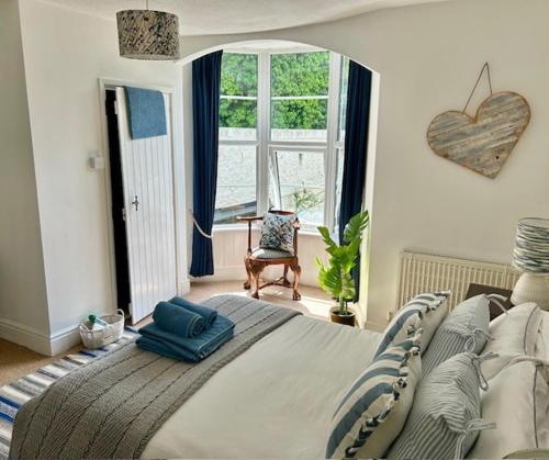 a bedroom with a large bed and a large window at Mews Cottage in Torquay