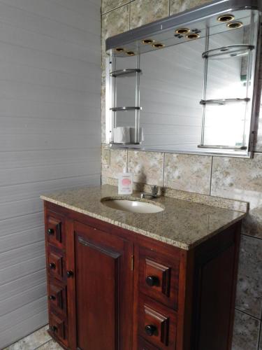 a bathroom with a sink and a mirror at Vibe Hostel Paraty in Paraty