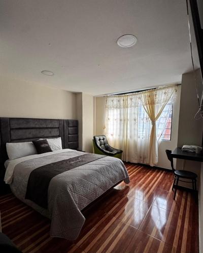 a bedroom with a large bed and a window at Hotel San Alejo in Ipiales
