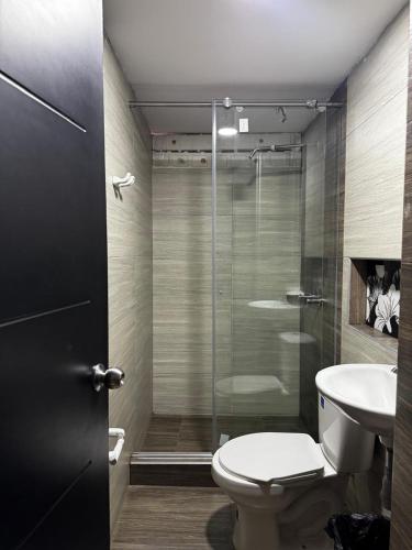 a bathroom with a shower and a toilet and a sink at Hotel San Alejo in Ipiales