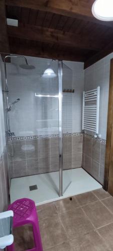 a shower with a purple stool in a bathroom at El Pontarron Apartamentos in La Franca