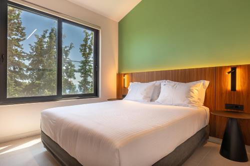a bedroom with a large bed with a large window at Black Mountain Villas in Kefallonia