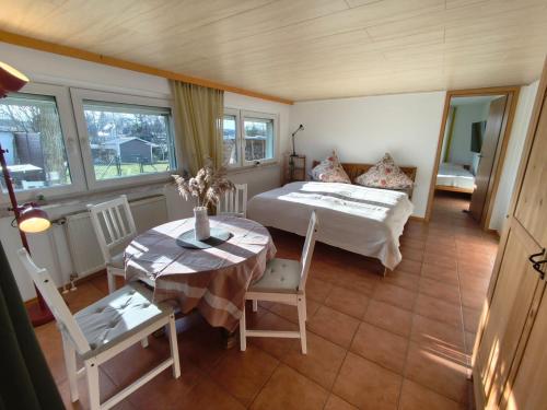 a bedroom with a bed and a table and a table and chairs at A short break on Germany's largest island in Garz