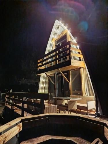 a building on top of a deck with chairs at Lake House Jeziorsko in Ostrów Warcki