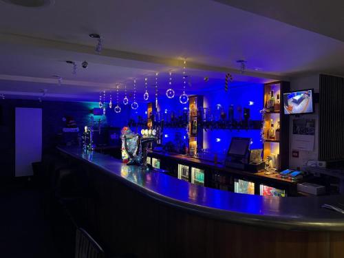 a bar with blue lights in a room at Ugie House in Keith