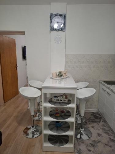 a kitchen with a white table and two stools at AMADA apartman in Vranješ
