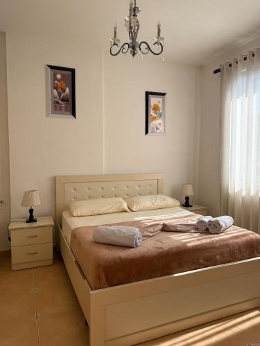 a bedroom with a large bed with a chandelier at Valentino Apartments in Shkodër