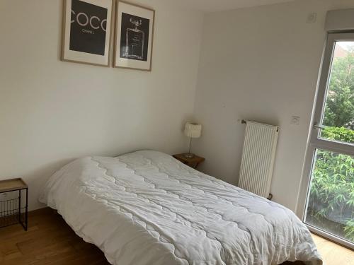 a white bed in a room with a window at Le 20 Joliot-Studio moderne in Mions