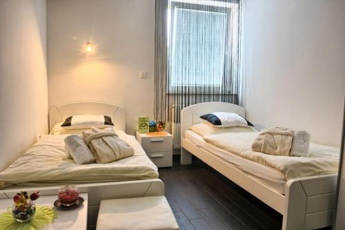 a small room with two beds and a window at Gril Ranca pod Pohorjem in Maribor