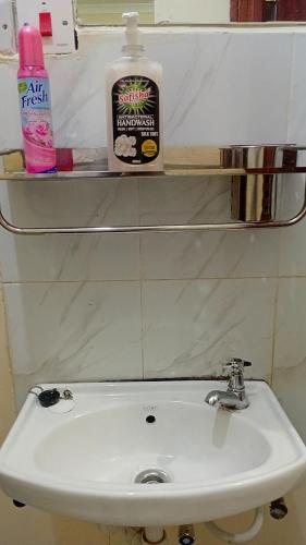 a white sink in a bathroom with a shelf above it at Jayson Homes in Thika