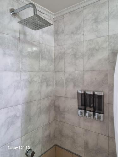 eine Dusche mit grau gefliester Wand und Duschkopf in der Unterkunft GORRITI VIEW in Partido Lomas de Zamora