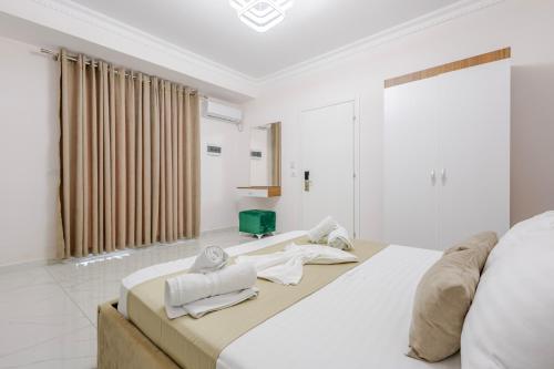 a bedroom with a large bed with towels on it at Golden Hill Ksamil in Ksamil