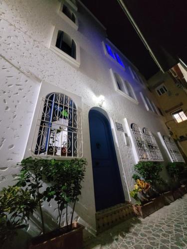 a white building with a blue door and a window at Dar Dahbia in Asilah