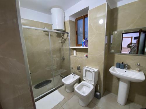 a bathroom with a toilet and a sink and a shower at Guest House Brahimasi in Çorovodë
